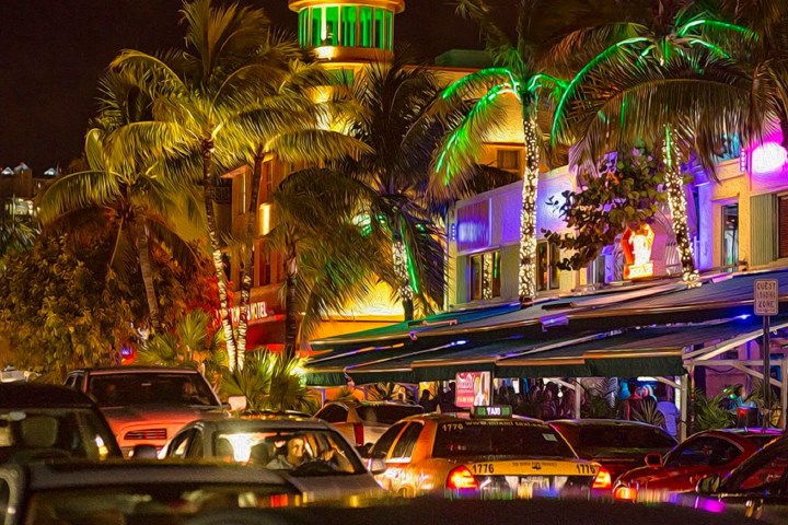 a car driving on a city street filled with traffic at night