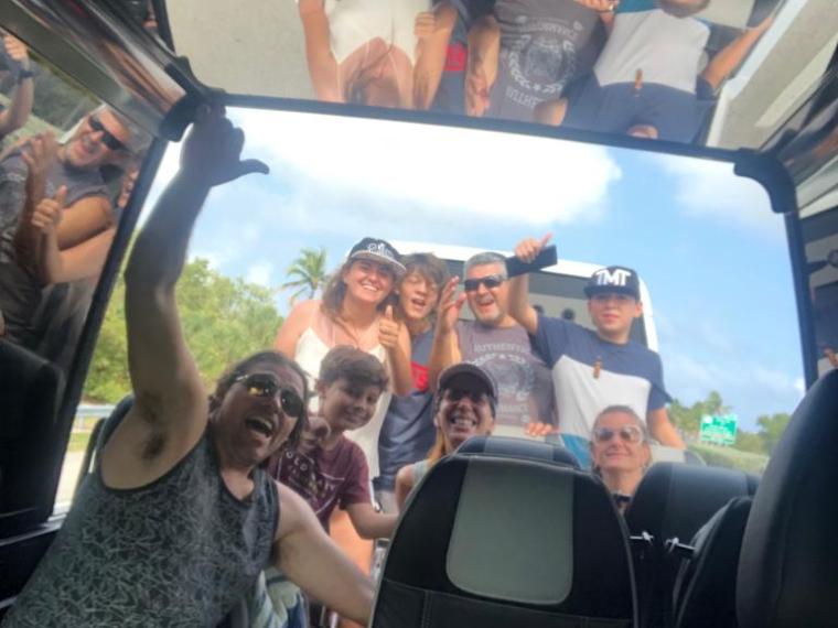 a group of people sitting around a car