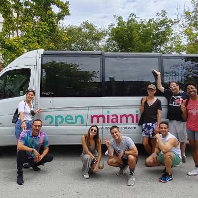 a group of people standing in front of a car posing for the camera