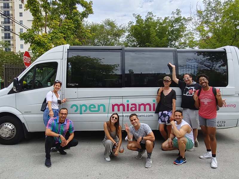 a group of people standing in front of a car posing for the camera