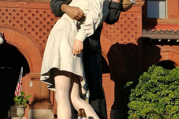 a person sitting on a bench in front of a brick building